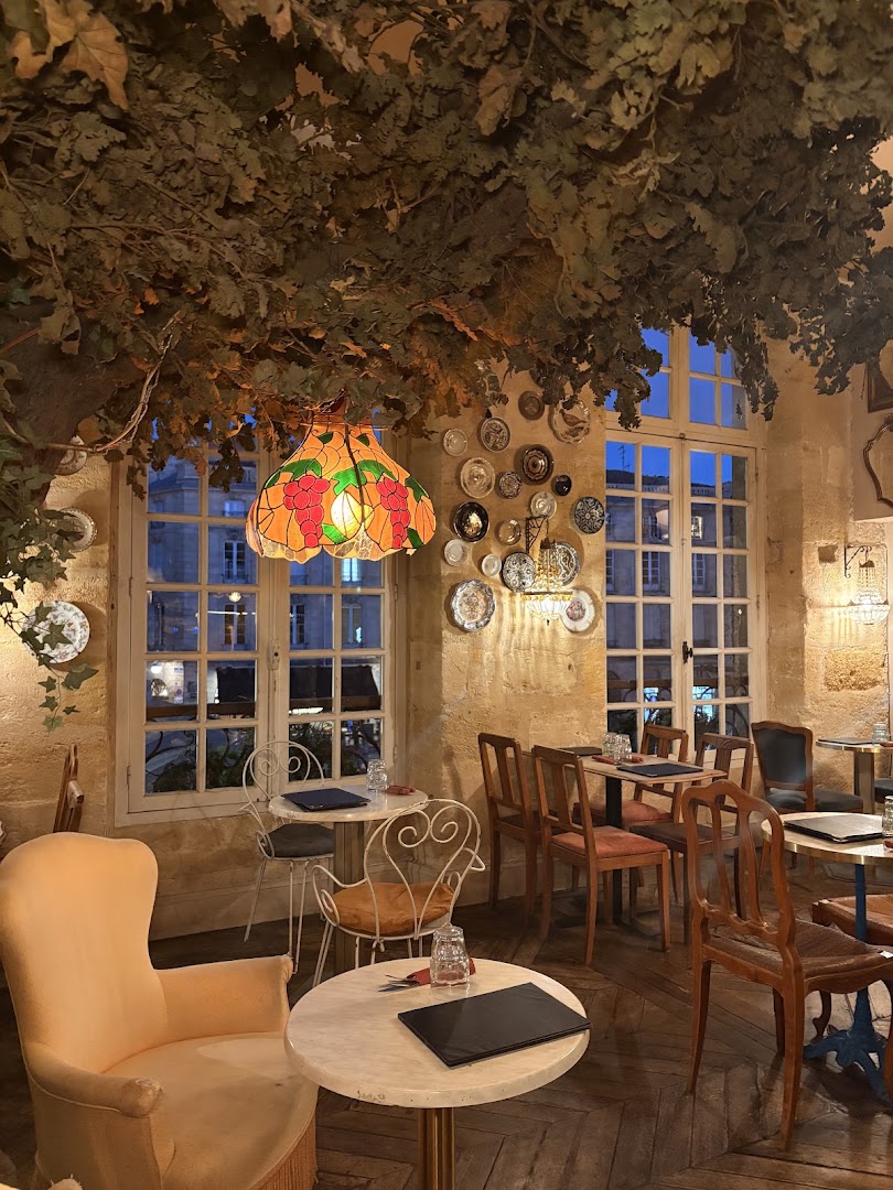 La salle vide avec sa lampe colorée, ses branches et ses tables