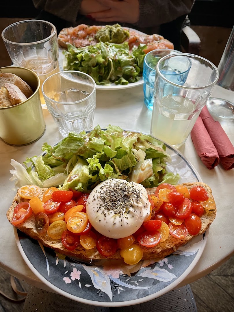 Une tartine aux tomates et à la burrata servie avec une salade